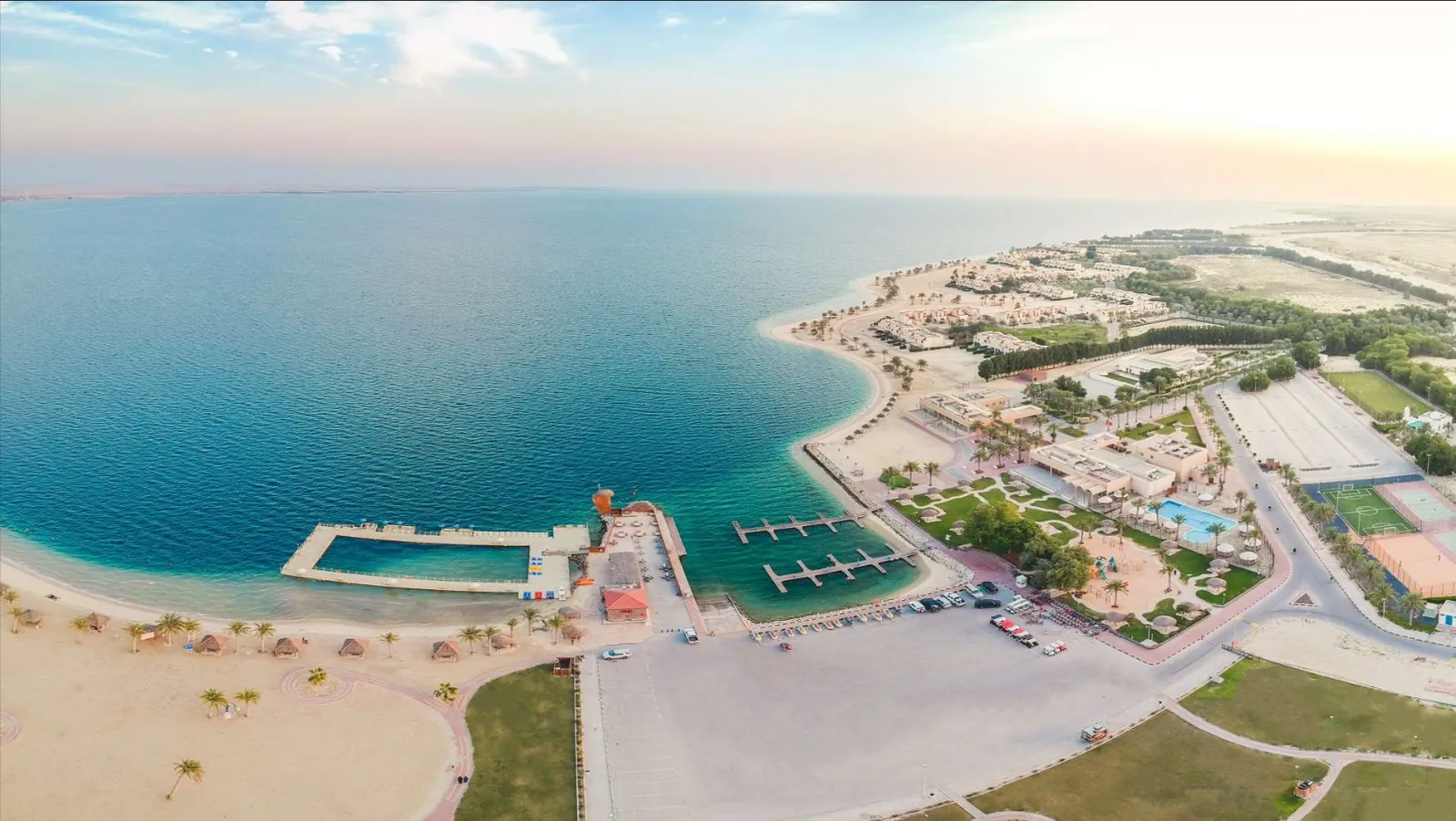 لقطة جوّية لمنتجع شاطئ النخيل ومرساه على شاطئ نصف القمر